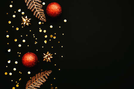 Gold bows and confetti and red Christmas balls Christmas or New Year dark background. There is empty space for text nearby.の写真素材