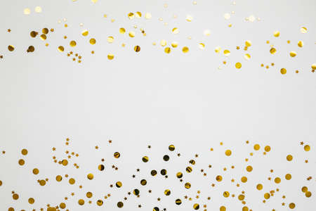 Gold and silver confetti on a white festive background. In the middle there is space for text or copy space.の写真素材