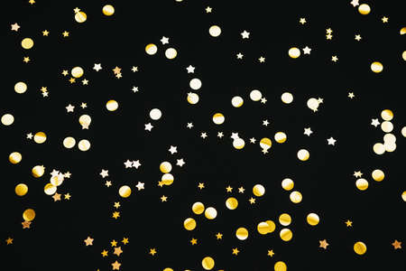 Gold confetti on a black festive background.の写真素材