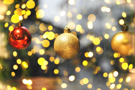 Gold and red balls on a blurred holiday background with many lights. Christmas and New Year...