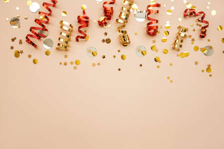 Gold and red Christmas ribbons and confetti on a pink background. Christmas or New Year conceptual background. There is empty space for text at the bottom.の写真素材