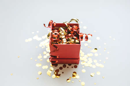 Open festive box with tinsel and confetti. Celebrating Christmas or New Years or winning a prize or a promotion or other holiday concept.の写真素材