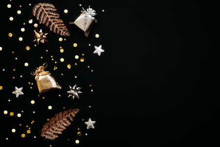 Gift bags, bows and confetti of gold and silver colors Christmas or New Years dark background or Black Friday. There is empty space for text nearby.の写真素材