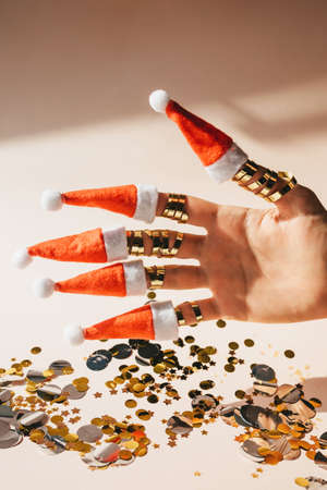 Hand with Santa Claus hats on fingers Christmas and New Year background.の写真素材