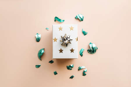 Box with a gift on a pink background, next to a broken Christmas tree toy. Festive concept background.の写真素材