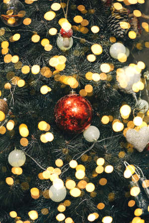 Close up of red ball Christmas tree toy. Festive background with many lights.の写真素材