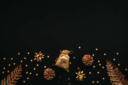 Various festive items and decorations in gold color on a dark or black background. Top space for text or copy space. Christmas or New Years concept.の写真素材