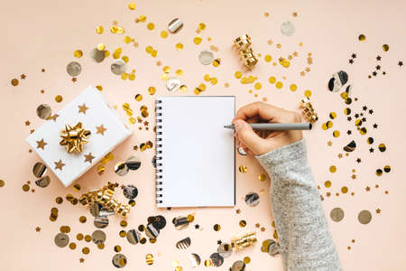 The girl writes goals for the New Year or a wish list or a letter to Santa in a notebook.の写真素材