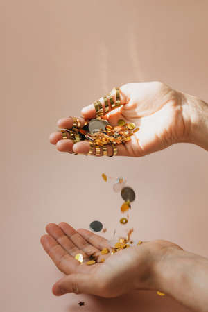 Human hands with falling confetti on a pink background. Festive concept.の写真素材