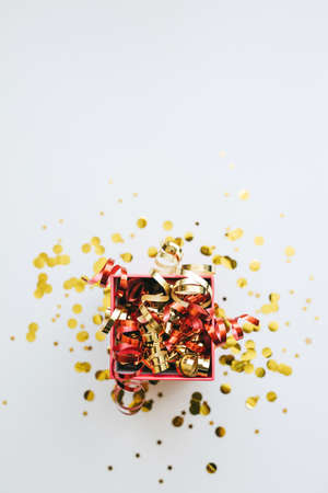 Open festive box with tinsel and confetti. Celebrating Christmas or New Years or winning a prize or a promotion or other holiday concept.の写真素材