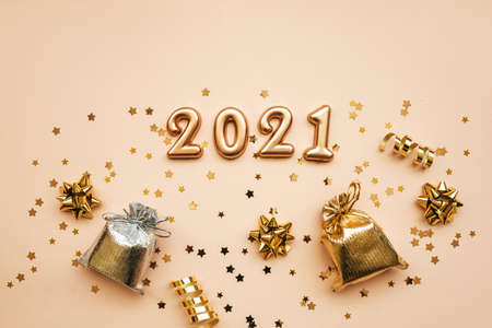 Top view of golden 2021 numbers and gifts and holiday decorations on pink background. New Year and Christmas background.の写真素材