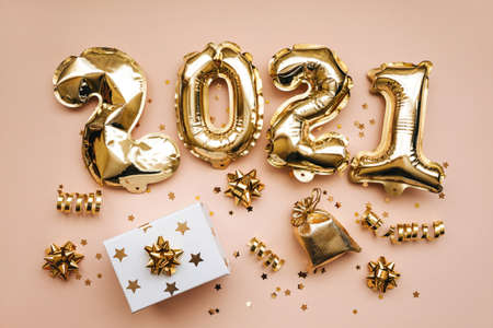 Top view of golden 2021 numbers and gifts and holiday decorations on pink background. New Year and Christmas background.の写真素材