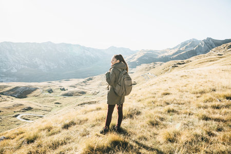 Young girl tourist or traveler alone on the background of a mountain landscape in autumn.の写真素材