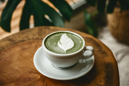 Fresh aromatic green matcha latte tea on a wooden table. Natural antioxidant and dietary product.の写真素材