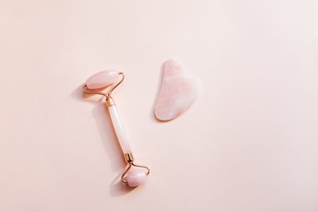 Roller for face massage and guasha on a pink background. Skin care products.の写真素材