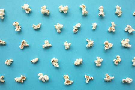 Popcorn scattered on blue background. Popcorn pattern. top view.