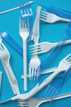 White plastic garbage on a blue background. The concept of plastic recycling and ecology. Plastic waste, cutlery. Flat lay, top viewの写真素材