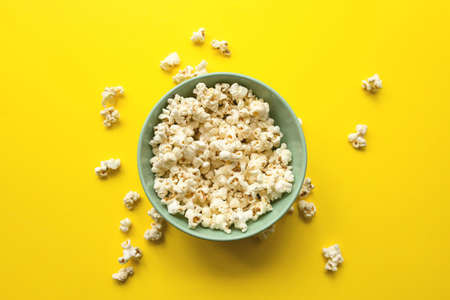 Delicious popcorn in bowl and on yellow background close-up. Food and snack concept.の写真素材