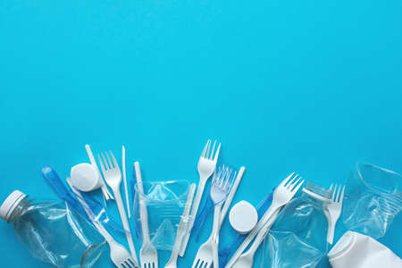 White plastic garbage on a blue background. The concept of plastic recycling and ecology. Plastic waste, cutlery. Flat lay, top viewの写真素材