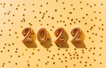 Balloons made of gold foil with the numbers 2022 on a gold background. Celebrating Christmas, New Years and holiday concept. Flat lay, top view.の写真素材