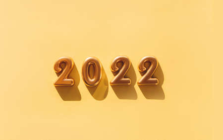 Balloons made of gold foil with the numbers 2022 on a gold background. Celebrating Christmas, New Years and holiday concept. Flat lay, top view.の写真素材