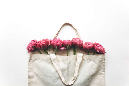 Bouquet of pink tulips in a canvas bag on a white background. Flat lay, top view.の写真素材