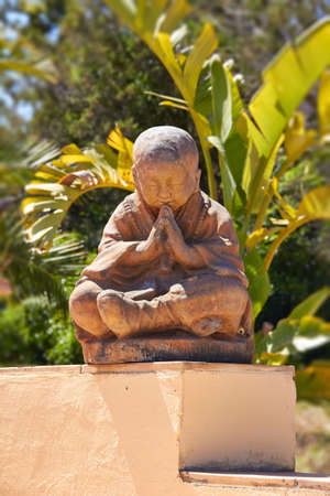 Sitting Buddha Meditation against Green Plants Background の写真素材
