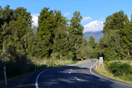 Road through the stunning landscape of New Zealand's West Coast on the South Island with forests and snowy mountains or Southern Alpsの写真素材
