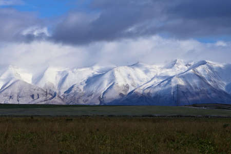 Scenic landscape with snow covered Southern Alps mountain range in the vastness of New Zealand, South Island near Mount Cook on a cloudy morningの写真素材