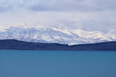 Scenic winter landscape in New Zealand- blue lake pukaki and snow covered Southern Alps on the South Islandの写真素材
