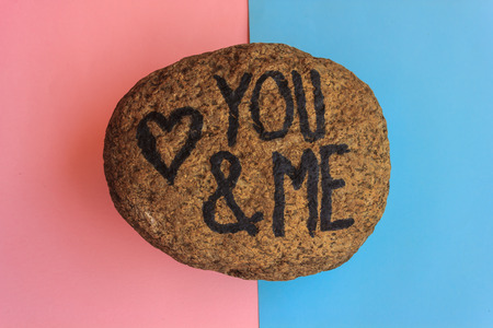 the writing you and me with a heart drawn on a stone,indicates the love promise of two loversの写真素材