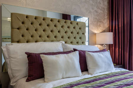 Cambridge, Cambridgeshire - June 9 2011: Modern bedroom detail with green button fabric headboard...