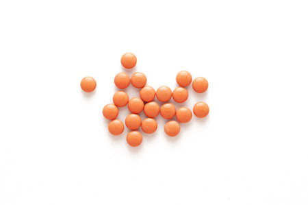 Loose orange pills on a white backgroundの写真素材