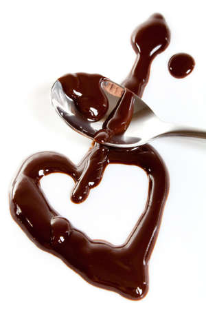 Melted dark chocolate on plate and steel spoon. Heart shapeの写真素材