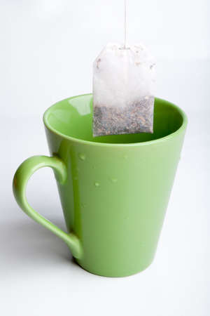 Green tea cup with tea bag isolated on light grey backgroundの写真素材