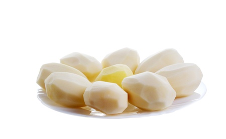 some cleared potatoes on plate. isolated on white backgroundの写真素材