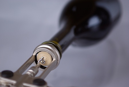 the corkscrew opens a wine bottle. focus is on the corkの写真素材