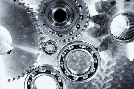 titanium and steel engineering parts set against brushed aluminumの写真素材