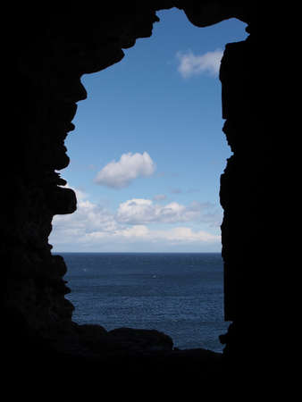 sea and sky seen through a hole in a stone wallの写真素材