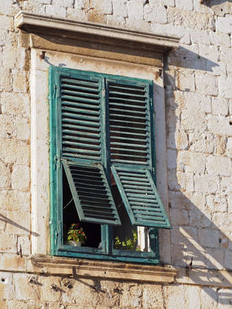 old mediterranean window with green shuttersの写真素材
