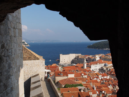 Dubrovnik, Croatia, august 2013, medieval city roofs and harbor framed by a stone archのeditorial素材