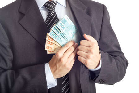 A businessman in a suit putting money in his pocket isolated on white background