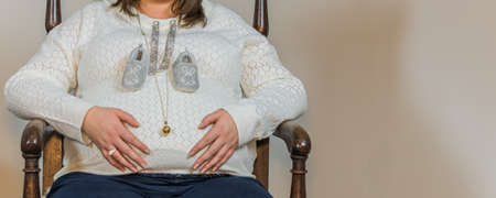 Close-up on the belly of a pregnant woman wearing a pregnancy bola