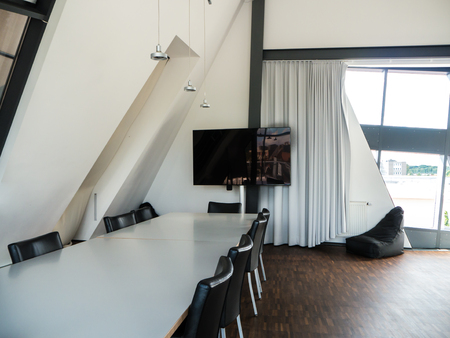 Meeting room with white table and black chairsの写真素材