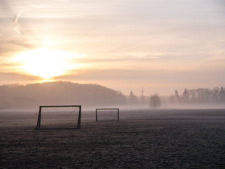 Beautiful foggy soccer pitch on a field at sunriseの写真素材