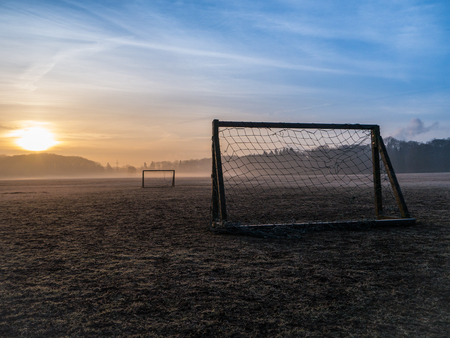 Beautiful foggy soccer pitch on a field at sunriseの写真素材