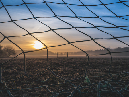 Beautiful foggy soccer pitch on a field at sunriseの写真素材