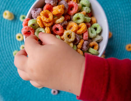 Kid's hand touching Breakfast Cereal Bowlの写真素材