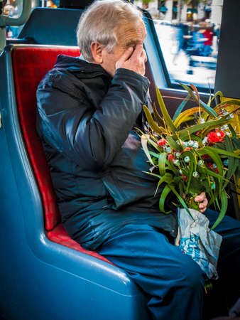 Barcelona, Spain - 08 December, 2016: Old man sitting on the bus carrying flowers.の写真素材