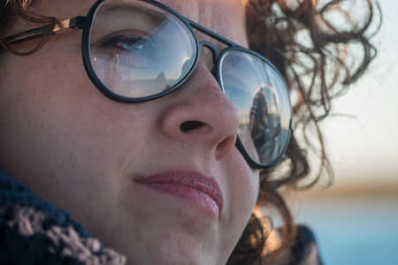 Close of Young curly haired woman wearing glasses on boat tour.の写真素材